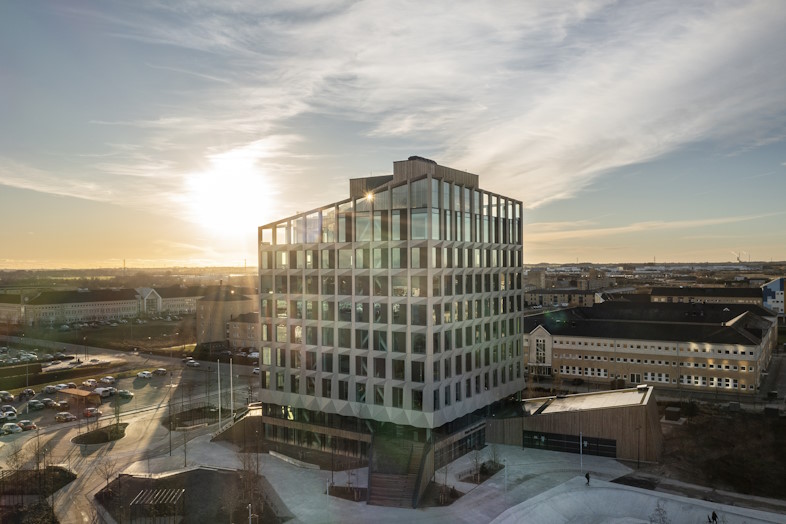 Facade med champagnefarvede elementer og store glaspaneler