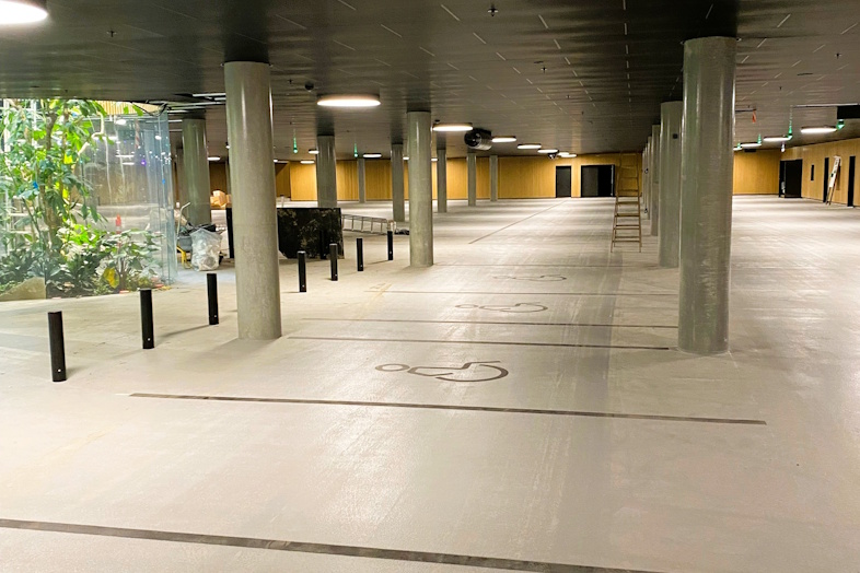 Areos montører har udlagt i alt 10.000 m² i Operaparkens fleretagers P-hus. Billedet her er taget i forbindelse med afleveringen af den meget specielle opgave. Her skulle der lægges gulv omkring en stor glasmontre med et 10 meter højt, afrikansk træ indeni. 