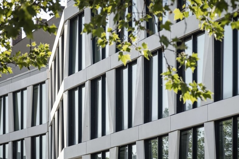 Den firdelte kontorbygning MARK i München imponerer med sin markante, foldede facadestruktur med tredimensionelle elementerDen firdelte kontorbygning MARK i München imponerer med sin markante, foldede facadestruktur med tredimensionelle elementer